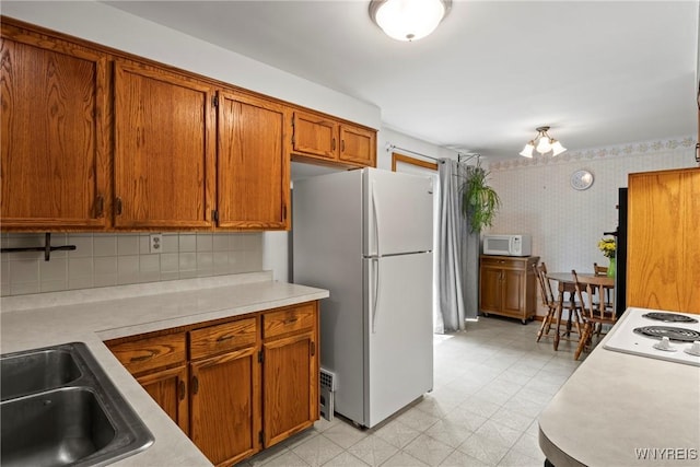 301 Pleasant View Dr, Lancaster, NY 14086 - kitchen featuring white appliances, wallpapered walls, light countertops, brown cabinets, and light flooring