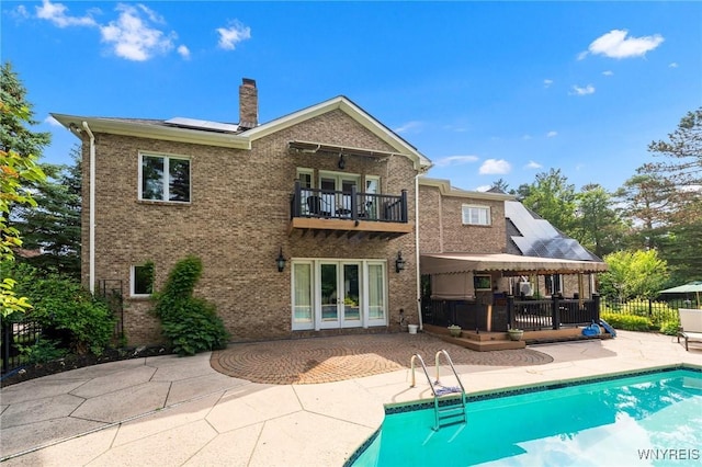 7 The Hamlet, Amherst, NY 14051 - back of property with a balcony, a patio, solar panels, a chimney, and french doors