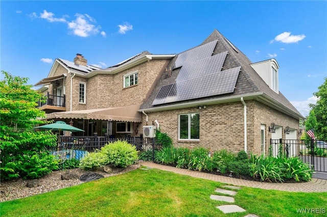 7 The Hamlet, Amherst, NY 14051 - rear view of property featuring roof mounted solar panels, brick siding, a balcony, a garage, and a chimney