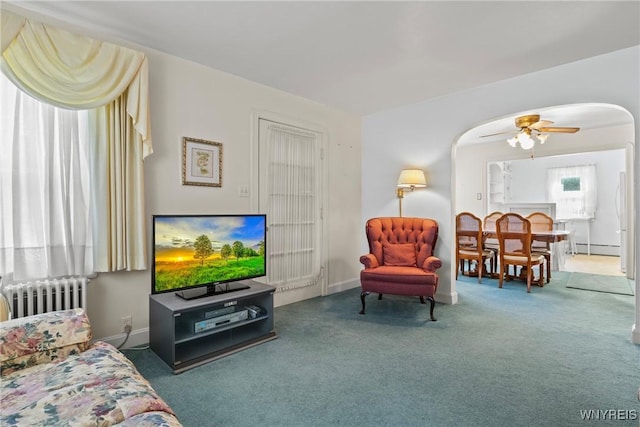 1419 Maple Rd, Amherst, NY 14221 - carpeted living area featuring radiator, arched walkways, a baseboard heating unit, and ceiling fan