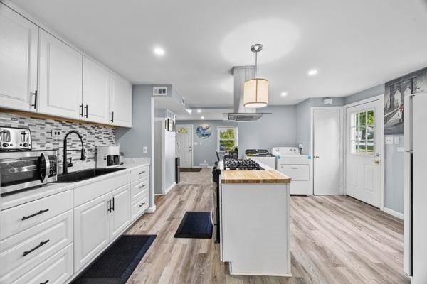 95 Ridgemar Rd, Greece, NY 14615 - kitchen with washer and clothes dryer, stainless steel microwave, wooden counters, white cabinets, and decorative backsplash