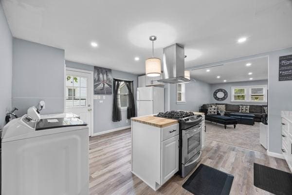 95 Ridgemar Rd, Greece, NY 14615 - kitchen with freestanding refrigerator, gas stove, island exhaust hood, washer and dryer, and white cabinets