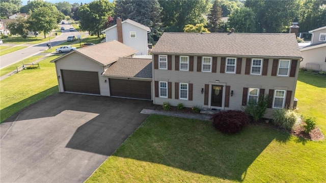 193 Orchard Creek Ln, Greece, NY 14612 - colonial house featuring a garage, driveway, a front lawn, and roof with shingles