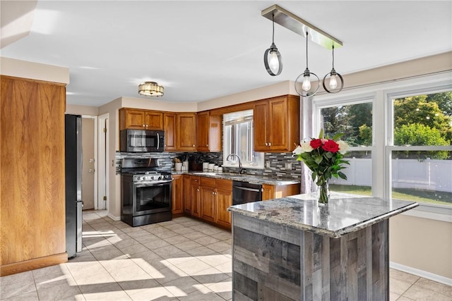 193 Orchard Creek Ln, Greece, NY 14612 - kitchen with stainless steel appliances, decorative backsplash, stone counters, and brown cabinets