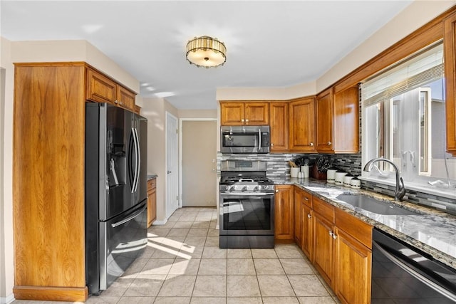 193 Orchard Creek Ln, Greece, NY 14612 - kitchen featuring appliances with stainless steel finishes, light stone countertops, backsplash, and brown cabinetry
