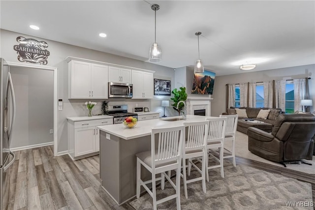 3398 Cedar Valley Way, Hamburg, NY 14075 - kitchen with stainless steel appliances, open floor plan, light countertops, a kitchen breakfast bar, and recessed lighting