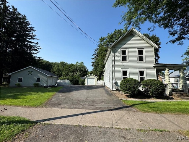 410 W Elm St, Oneida, NY 13421 - view of home's exterior featuring an outbuilding, a lawn, driveway, and a garage