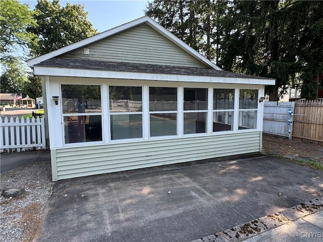 410 W Elm St, Oneida, NY 13421 - view of side of home with a sunroom, a patio, and a shingled roof