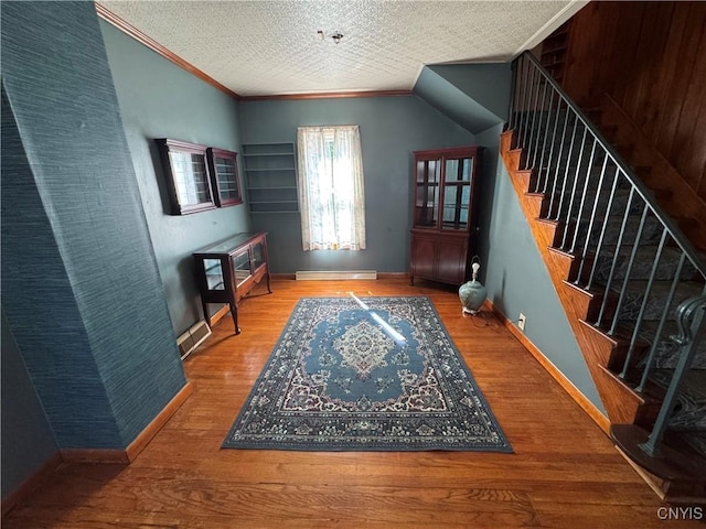 410 W Elm St, Oneida, NY 13421 - foyer entrance with ornamental molding, wood finished floors, stairs, and a baseboard radiator