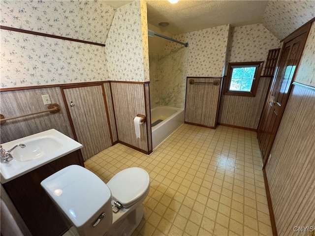 410 W Elm St, Oneida, NY 13421 - full bathroom featuring wallpapered walls, washtub / shower combination, vanity, and vaulted ceiling