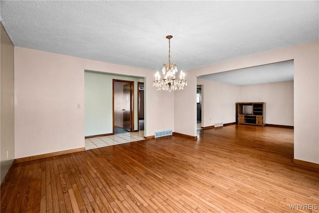 270 N French Rd, Amherst, NY 14228 - unfurnished living room with wood-type flooring and a chandelier