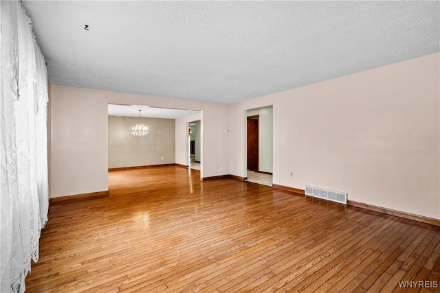 270 N French Rd, Amherst, NY 14228 - spare room featuring a chandelier, light wood-style flooring, and a textured ceiling