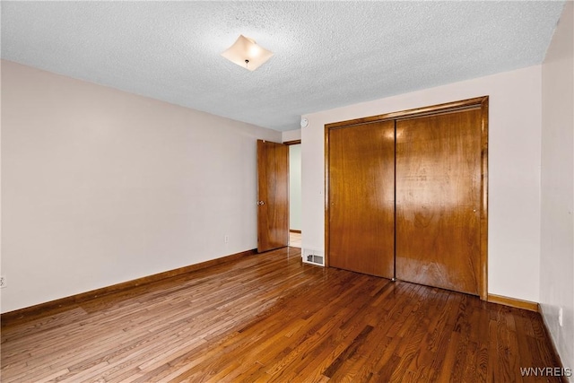 270 N French Rd, Amherst, NY 14228 - unfurnished bedroom featuring wood finished floors, a closet, and a textured ceiling