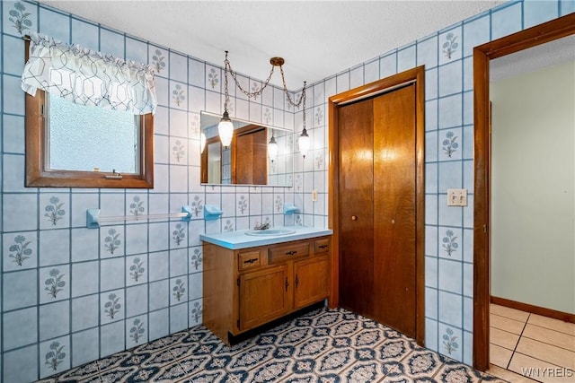 270 N French Rd, Amherst, NY 14228 - bathroom featuring vanity, a textured ceiling, tile patterned flooring, and tile walls