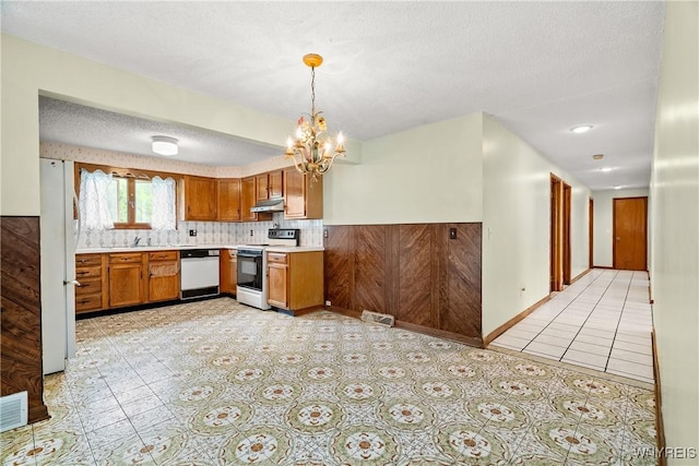 270 N French Rd, Amherst, NY 14228 - kitchen featuring range with electric cooktop, dishwasher, under cabinet range hood, light countertops, and a chandelier