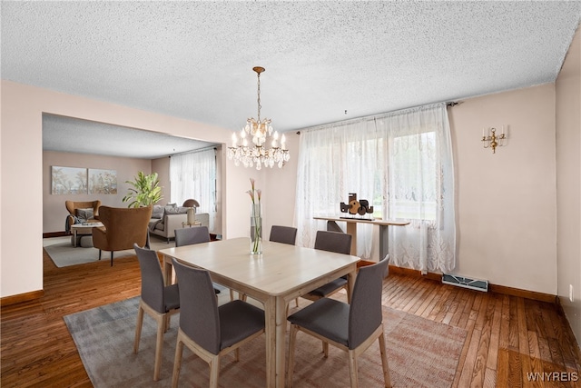 270 N French Rd, Amherst, NY 14228 - dining room with a chandelier, a textured ceiling, and hardwood / wood-style flooring