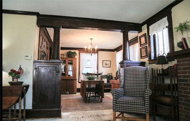 561 W Washington Ave, Elmira City, NY 14901 - living area with healthy amount of natural light, a chandelier, crown molding, wood finished floors, and ornate columns