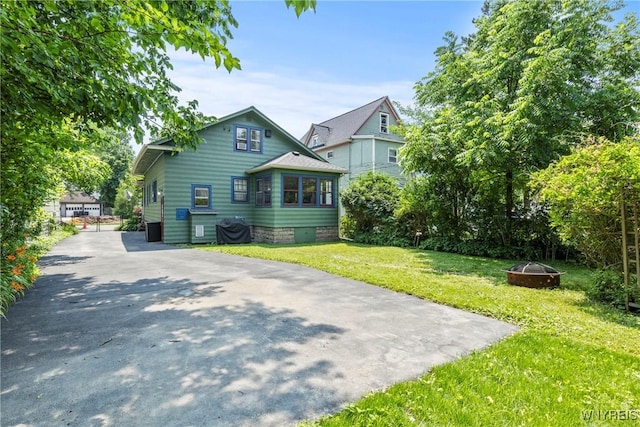 49 Mang Ave, Tonawanda, NY 14217 - view of home's exterior featuring a fire pit, a lawn, and asphalt driveway
