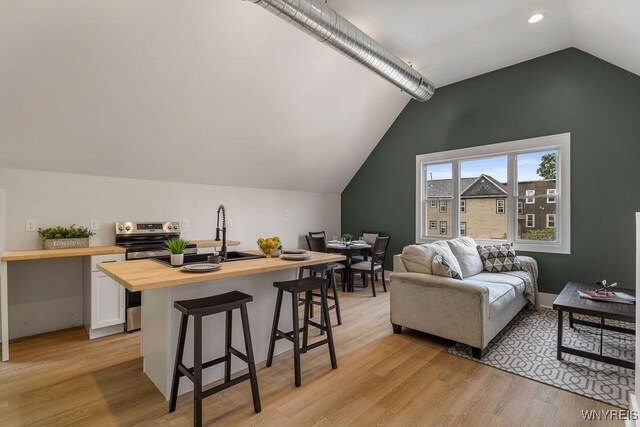 145 14th St, Buffalo, NY 14213 - living room featuring vaulted ceiling, light wood-style flooring, a desk, and recessed lighting