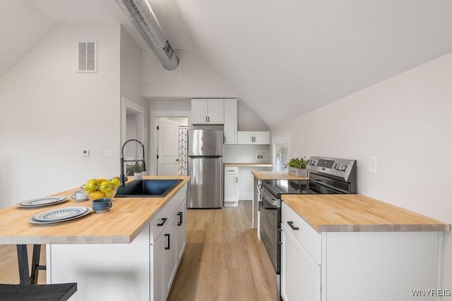 145 14th St, Buffalo, NY 14213 - kitchen with appliances with stainless steel finishes, butcher block counters, light wood-type flooring, white cabinetry, and a kitchen bar