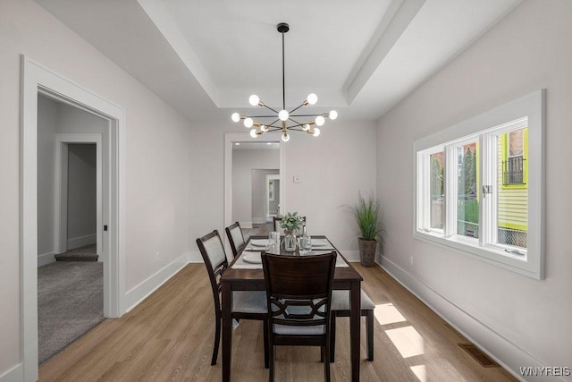145 14th St, Buffalo, NY 14213 - dining room with a raised ceiling, light wood finished floors, and a chandelier