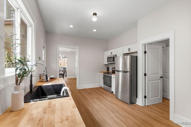 145 14th St, Buffalo, NY 14213 - kitchen with appliances with stainless steel finishes, light wood-style floors, white cabinetry, and recessed lighting
