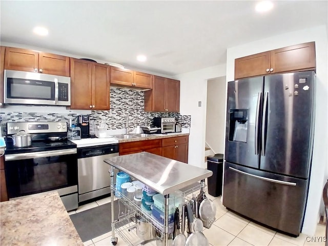 128 Dorando Way, Salina, NY 13090 - kitchen featuring appliances with stainless steel finishes, light countertops, tasteful backsplash, recessed lighting, and brown cabinetry