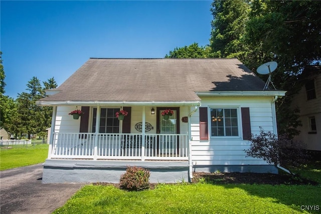 123 Branch St, Deerfield, NY 13502 - view of front of house featuring covered porch, a front lawn, and a shingled roof