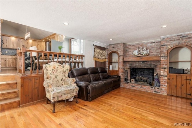 131 Shady Grove Dr, Amherst, NY 14051 - living room with wood finished floors, a textured ceiling, a brick fireplace, and recessed lighting