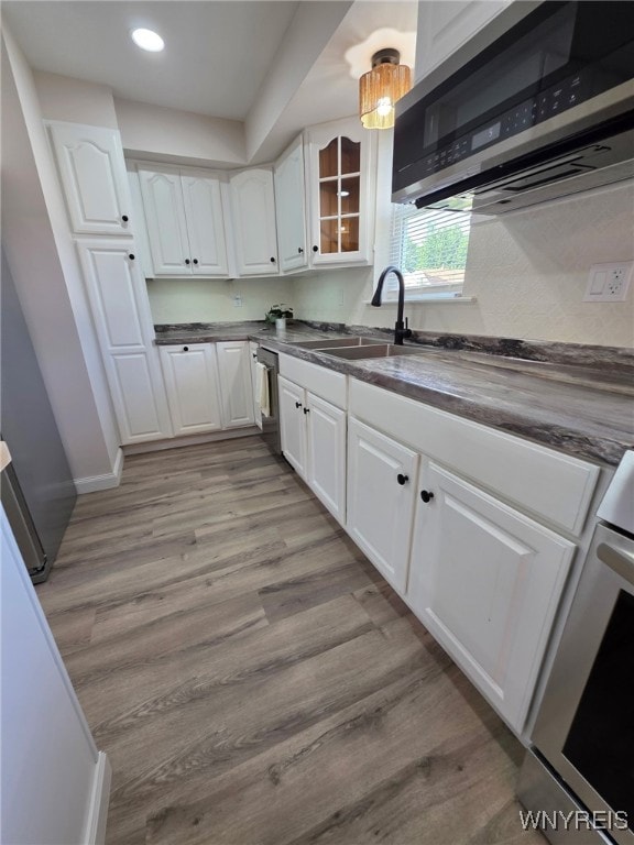 24 Wenonah, Tonawanda, NY 14150 - kitchen featuring stainless steel microwave, dark countertops, white cabinetry, light wood-style floors, and recessed lighting