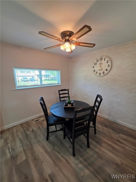 24 Wenonah, Tonawanda, NY 14150 - dining room with wood finished floors, brick wall, and a ceiling fan