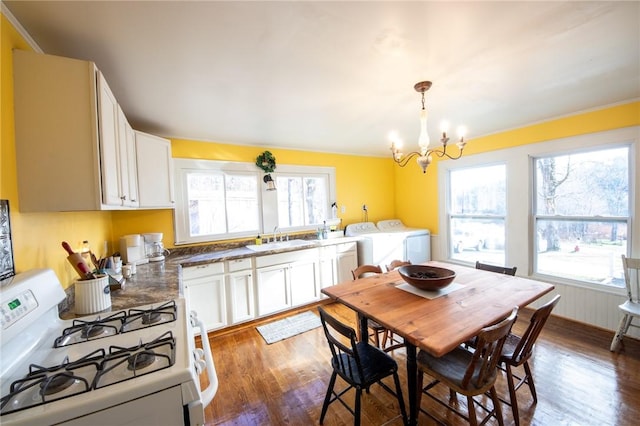345 Dorr Edson Rd, Milford, NY 13820 - kitchen featuring white gas stove, washing machine and clothes dryer, healthy amount of natural light, and wood finished floors