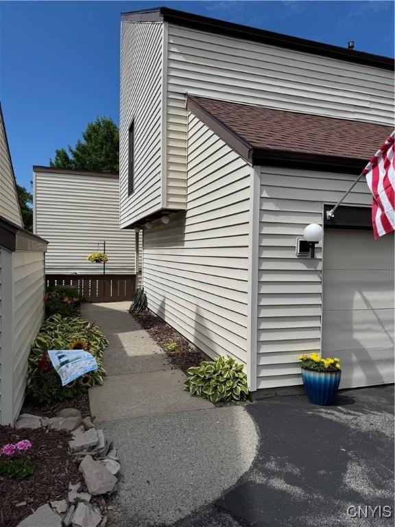 601 Woburn Dr, Camillus, NY 13031 - view of side of home with a garage and a shingled roof