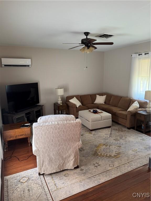 601 Woburn Dr, Camillus, NY 13031 - living area featuring a wall mounted air conditioner, a ceiling fan, and wood finished floors