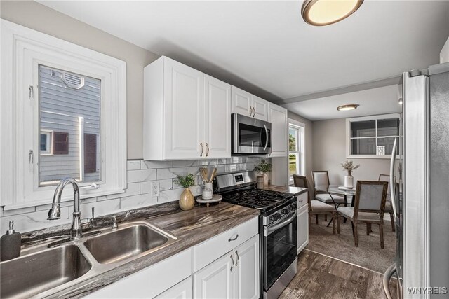 87 Ermann Dr, Tonawanda, NY 14217 - kitchen featuring stainless steel appliances, white cabinets, dark wood-style floors, tasteful backsplash, and dark countertops