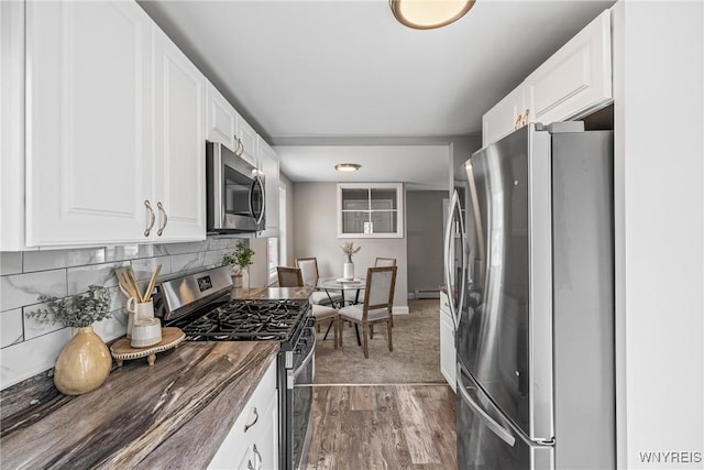 87 Ermann Dr, Tonawanda, NY 14217 - kitchen featuring appliances with stainless steel finishes, dark wood finished floors, white cabinetry, and backsplash