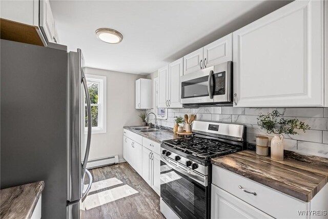 87 Ermann Dr, Tonawanda, NY 14217 - kitchen featuring appliances with stainless steel finishes, wood finished floors, tasteful backsplash, and white cabinetry