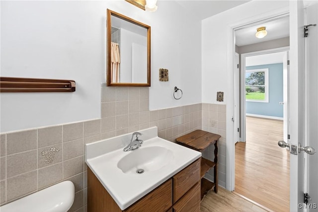 215 Rebecca St, Clay, NY 13212 - bathroom featuring tile walls, vanity, wood finished floors, and a wainscoted wall