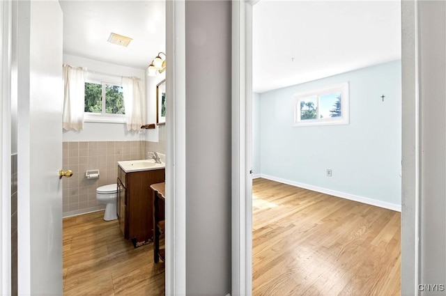 215 Rebecca St, Clay, NY 13212 - half bathroom with vanity, wood finished floors, tile walls, and a wainscoted wall