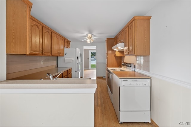 215 Rebecca St, Clay, NY 13212 - kitchen with white appliances, under cabinet range hood, a ceiling fan, decorative backsplash, and light countertops