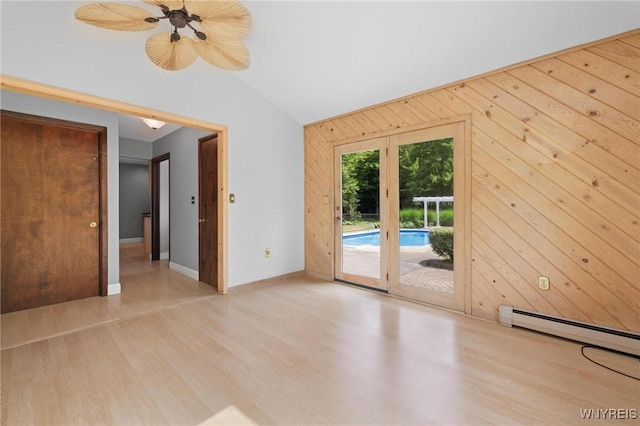 1575 Overhead Rd, Evans, NY 14047 - empty room featuring wood finished floors, vaulted ceiling, wood walls, and a baseboard radiator