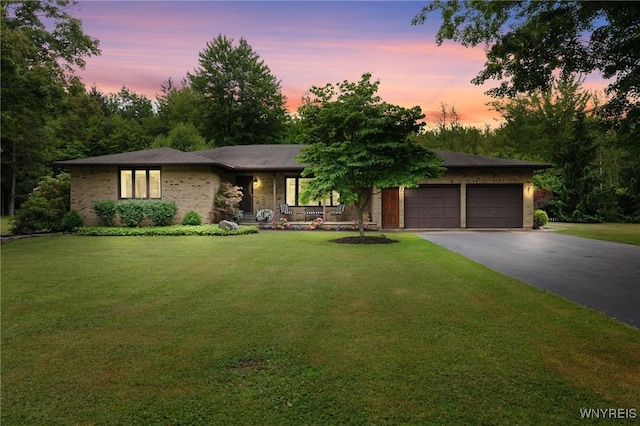 1575 Overhead Rd, Evans, NY 14047 - view of front of property with an attached garage, asphalt driveway, a lawn, and covered porch