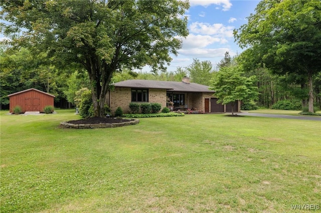 1575 Overhead Rd, Evans, NY 14047 - view of front facade featuring an attached garage, a shed, a front lawn, a chimney, and brick siding
