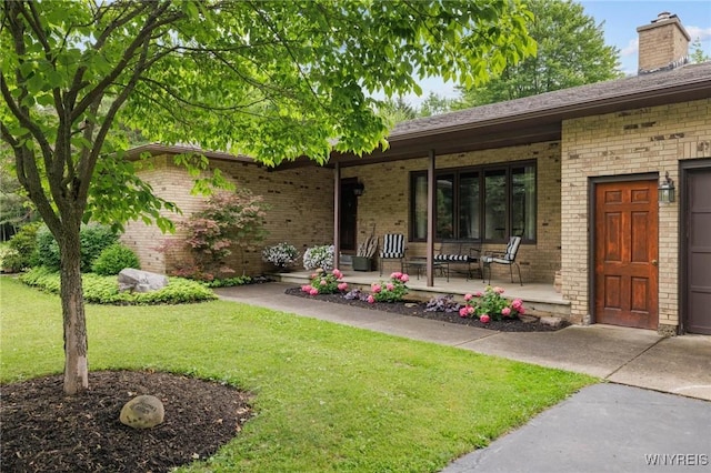 1575 Overhead Rd, Evans, NY 14047 - view of front of house featuring covered porch, brick siding, a front lawn, and a chimney