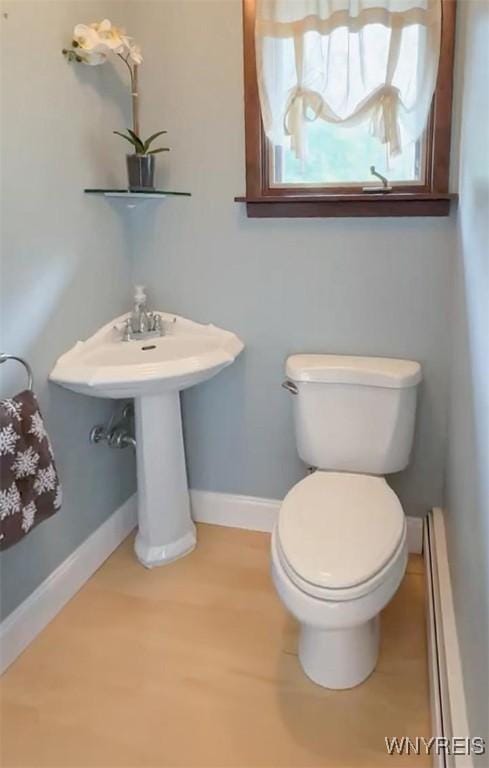 1575 Overhead Rd, Evans, NY 14047 - half bathroom with a baseboard heating unit and wood finished floors