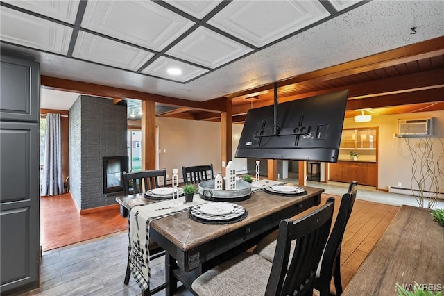 722 College Ter, Niagara Falls, NY 14305 - dining area featuring a wall mounted AC, light wood-type flooring, a baseboard heating unit, and a brick fireplace