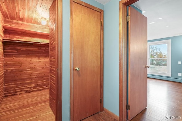 722 College Ter, Niagara Falls, NY 14305 - corridor featuring a baseboard heating unit, wood finished floors, wood walls, and wooden ceiling