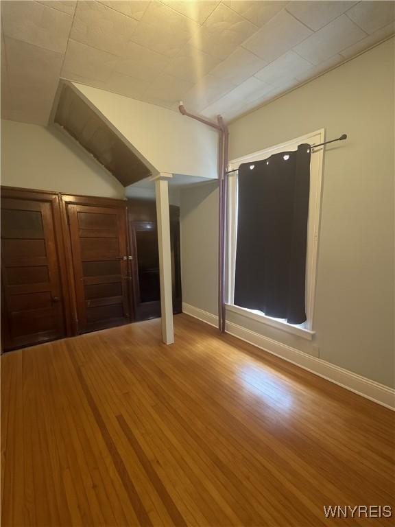 24 Northrup Pl, Buffalo, NY 14214 - unfurnished room featuring vaulted ceiling and wood finished floors