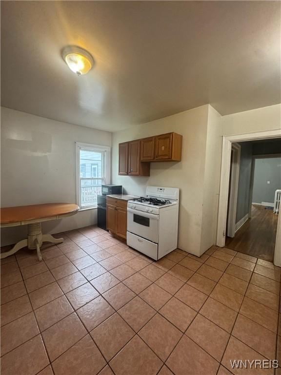 24 Northrup Pl, Buffalo, NY 14214 - kitchen with white range with gas stovetop and light tile patterned flooring
