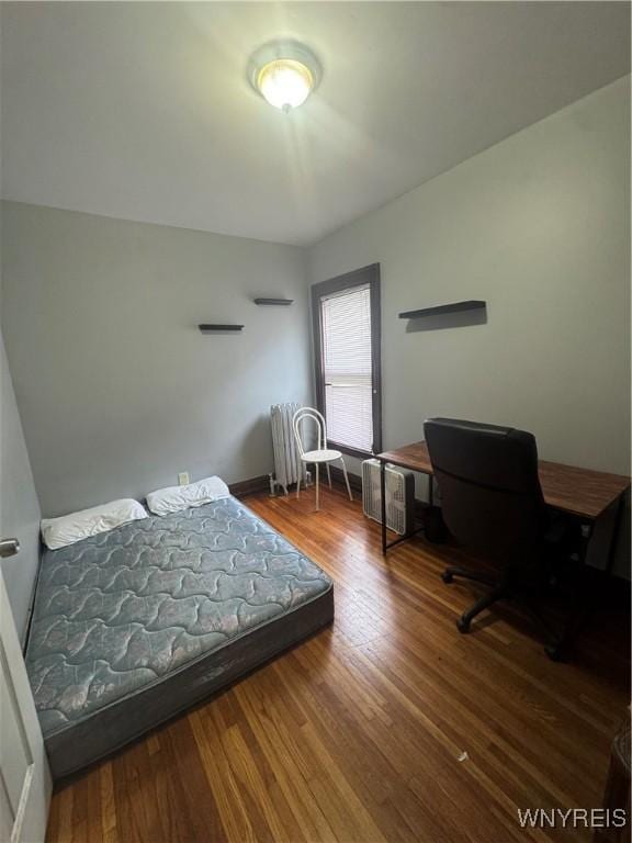 24 Northrup Pl, Buffalo, NY 14214 - bedroom featuring radiator heating unit, wood finished floors, and an office area